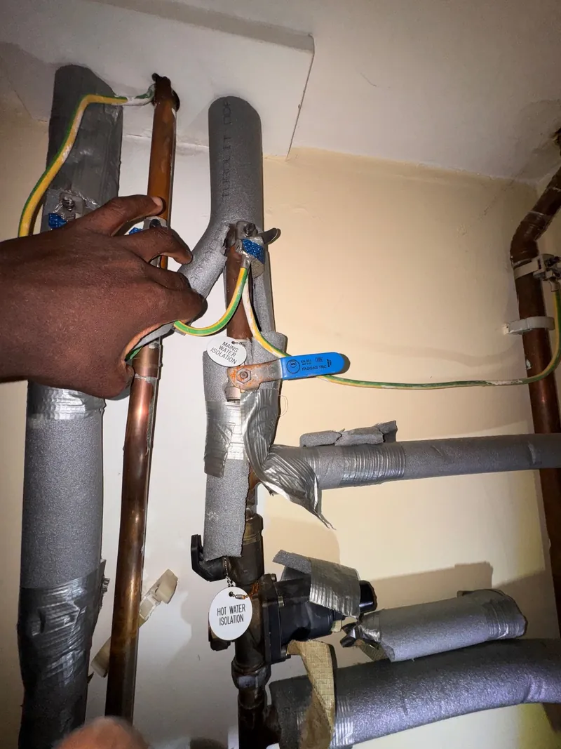 Lagged pipework with tagged mains water and hot water isolation valves at an unvented cylinder
